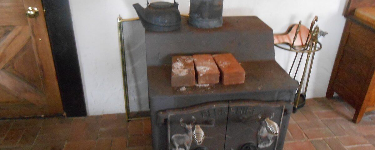 Old Wood Stove On Brick Hearth by Stocksy Contributor Brian